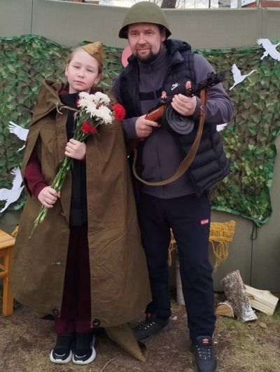 папа с автоматом в солдатской каске и доь в пилотке и плащ-палатке
