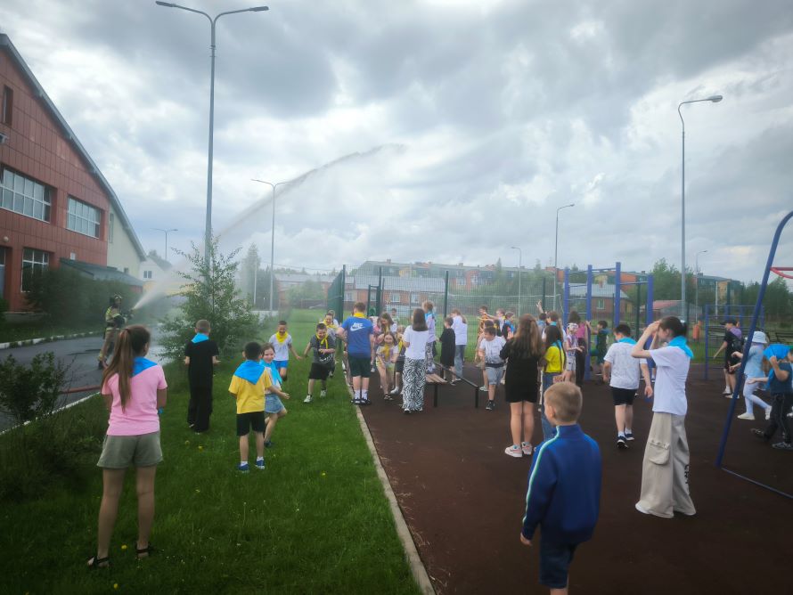 пожарный направил струю воды из пожарного ствола на детей