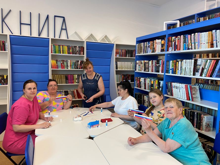участники акции делают книжные закладки с изображением триколора и миниатюрные флаги России своими руками