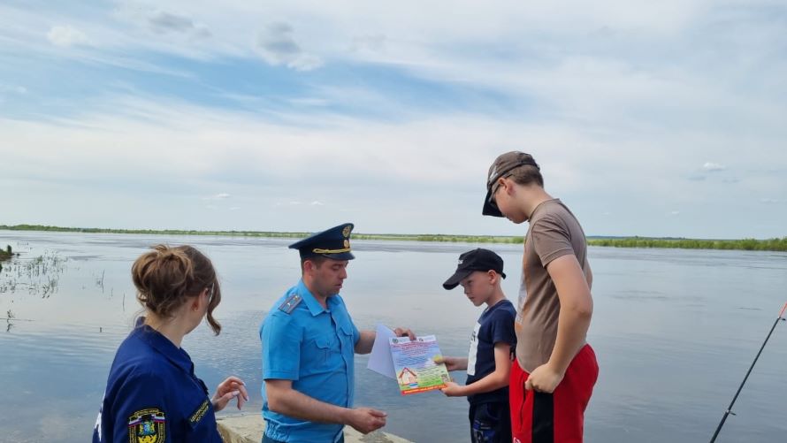 сотрудники пожарной охраны вручают памятки детям на берегу р. Конда