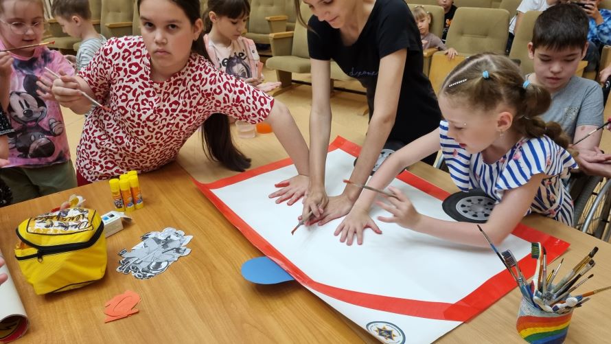 мальчишки и девчонки делают плакат на тему пожарной безопасности
