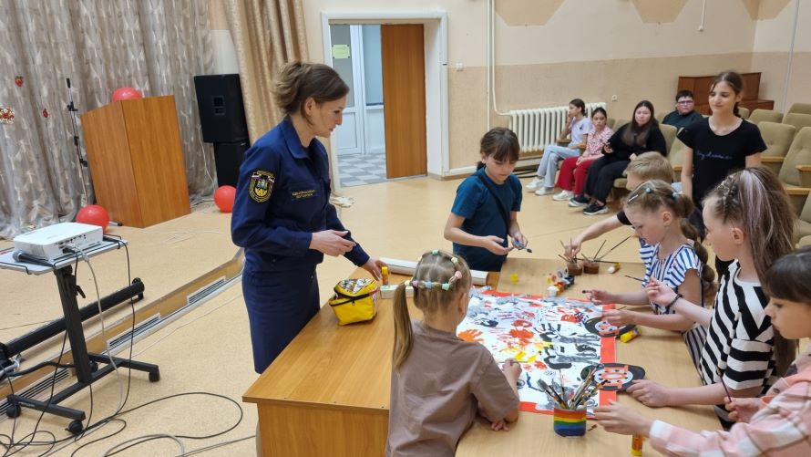 мальчишки и девчонки делают плакат на тему пожарной безопасности