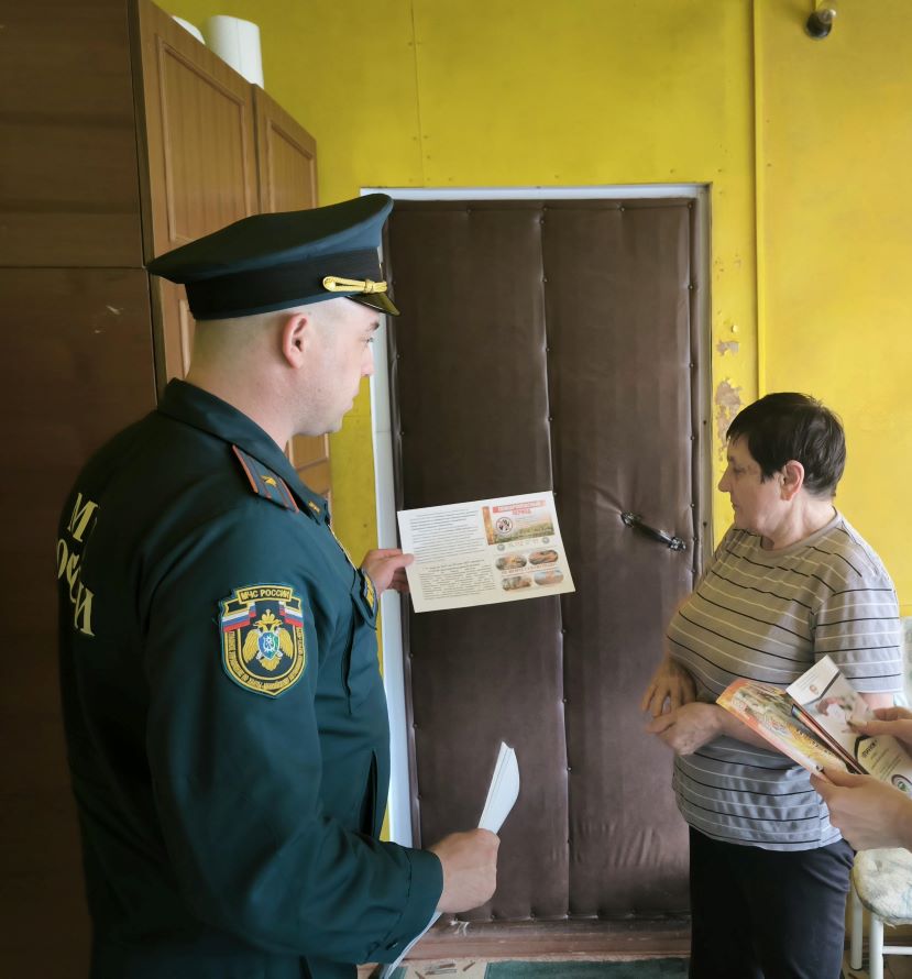 сотрудник пожарной охраны вручает памятки по ПБ