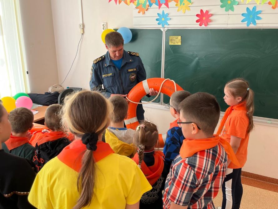 сотрудник МЧС показывает детям спасательный круг