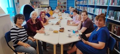 гости мероприятия за столом пьют чай