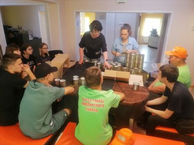 специалист-организатор объясняет ребятам как делать свечи