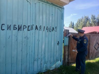 сотрудник мсч опускает памятку по пожарной безопасности в почтовый ящик частного дома