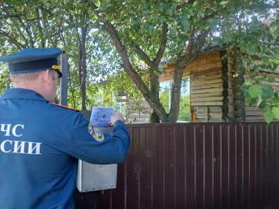 сотрудник мсч опускает памятку по пожарной безопасности в почтовый ящик