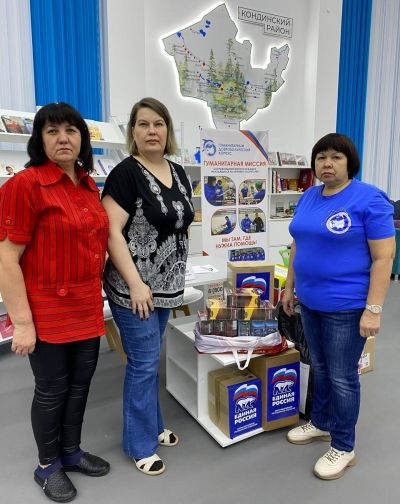 сотрудники библиотеки у стенда гуманитарной миссии