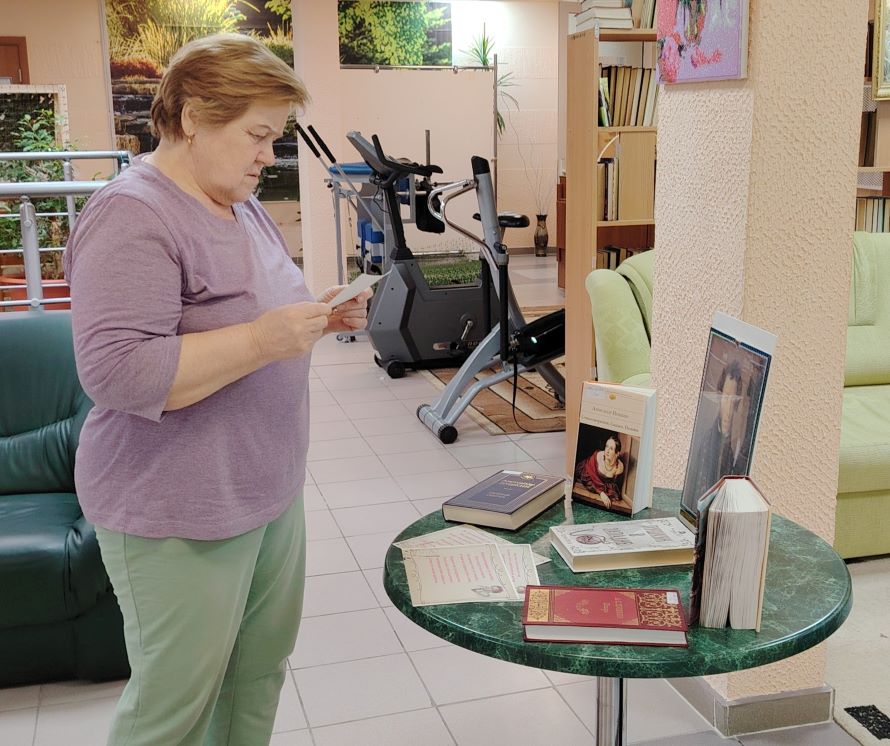 Гость мероприятия знакомится с книжной выставкой