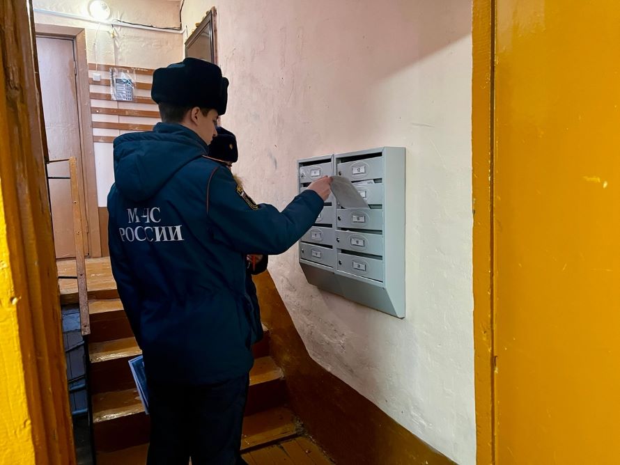 сотрудник отдела надзорной деятельности размещает памятки в почтых ящиках