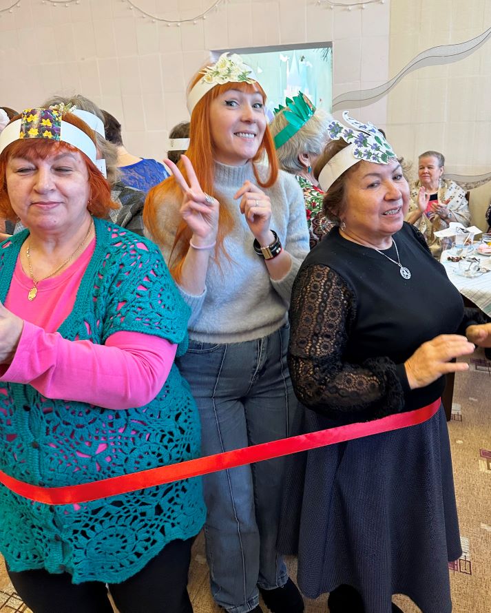 Группа женщин, на головах которых ободки с изображением цветов