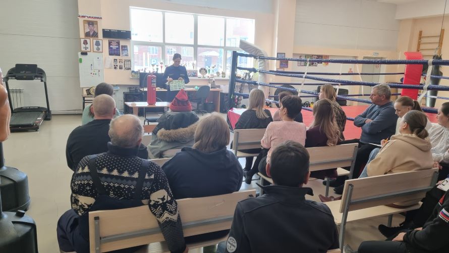 сотрудник пожарной охраны демонстрирует знаки пожарной безопасности