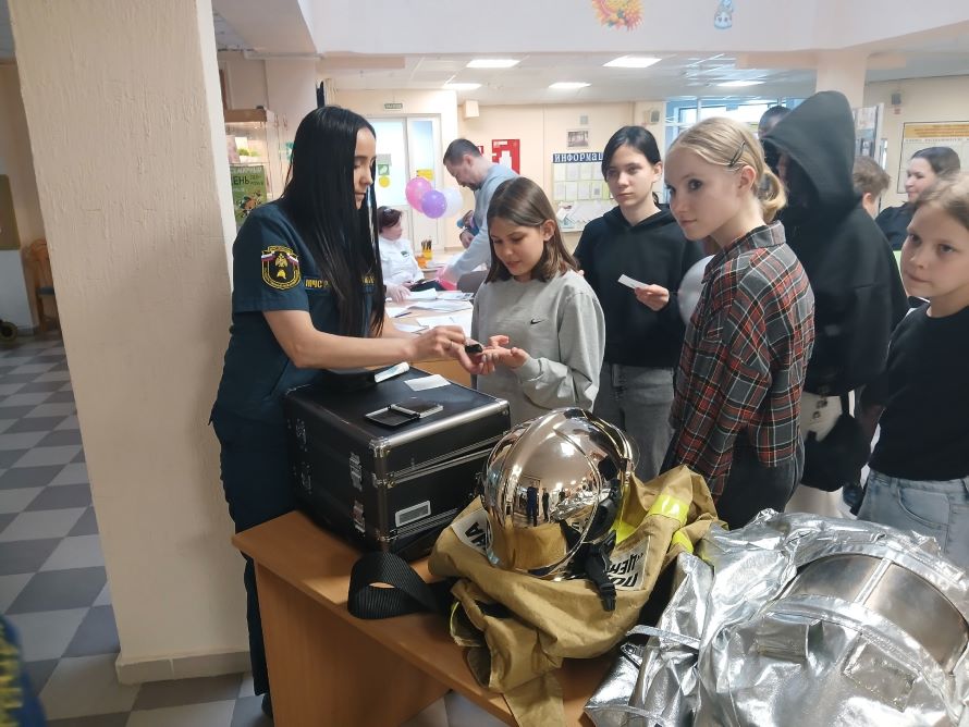 Сотрудник пожарной охраны снимает отпечатки пальцев у детей