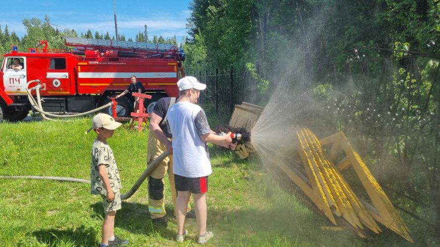 Ребенок пускает воду из пожарного ствола