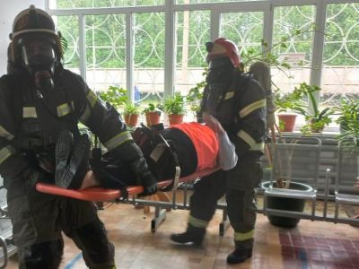 пожарные эвакуируют пострадавшего на носилках из здания вокзала