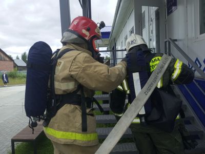 пожарные в боевой одежде поднимаются в здание амбулатории