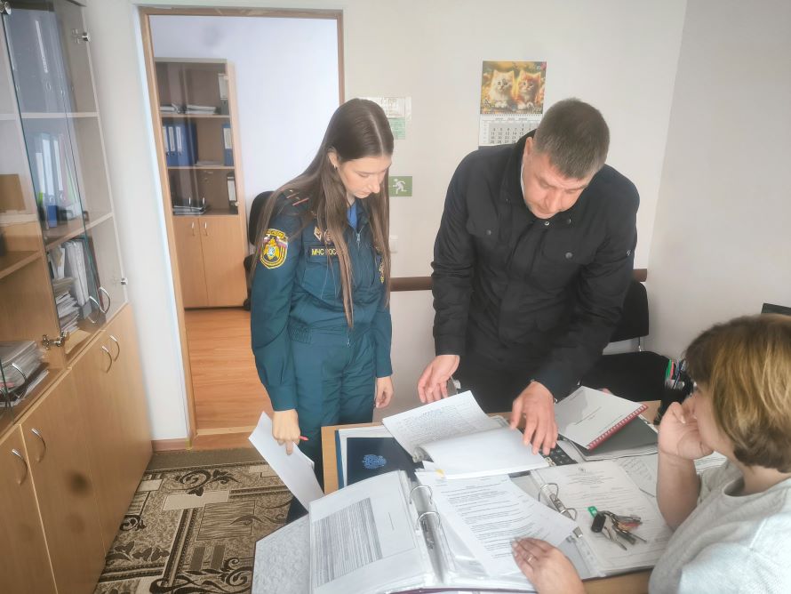 сотрудник пожарного надзора изучает документацию по пожарной безопасности на объекте