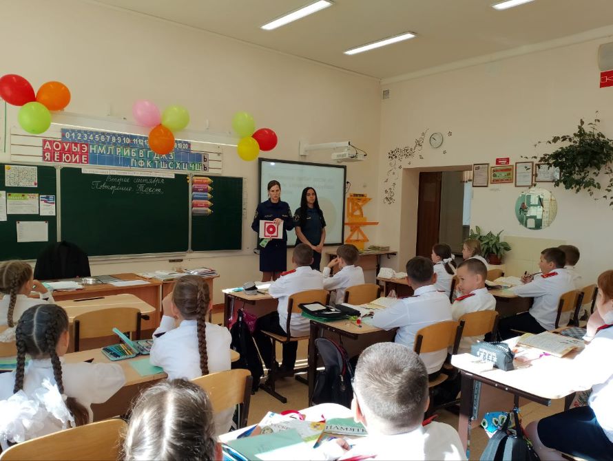 сотрудники пожарной охраны показывают детям знаки пожарной безопасности