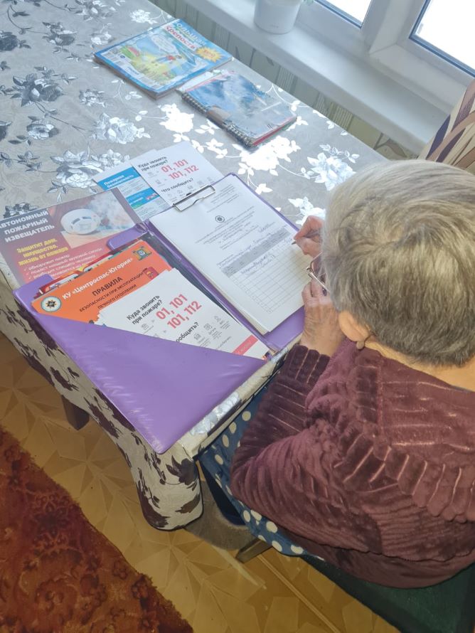 хозяйка дома изучает памятки по пожарной безопасности