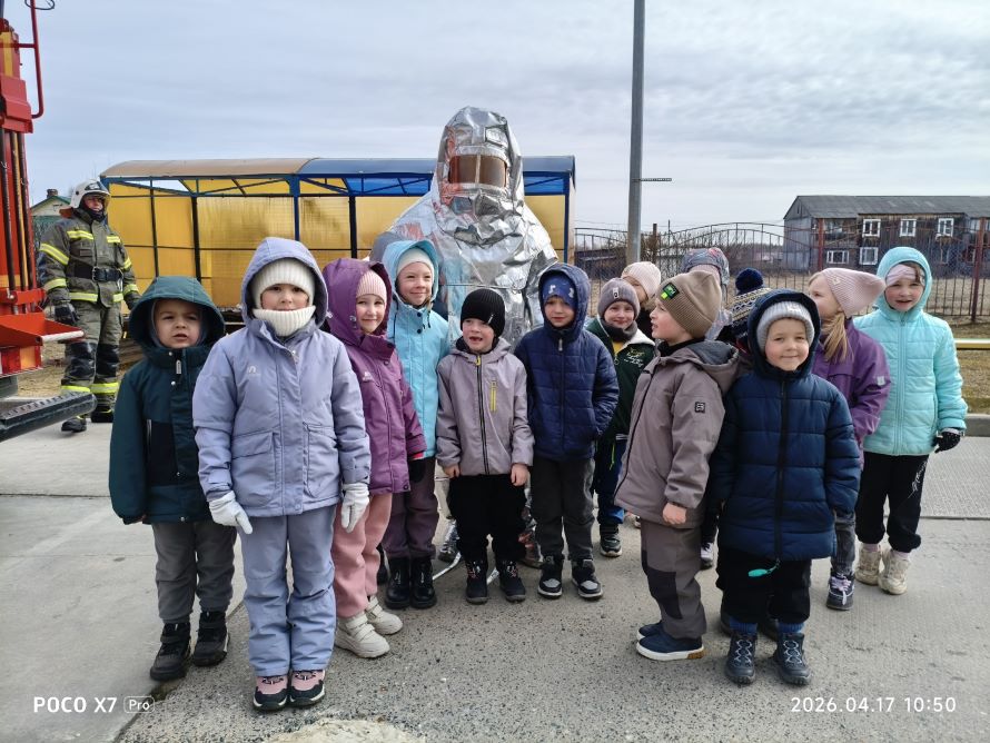 На фото дети с пожарным который одет в теплоотражательный костюм